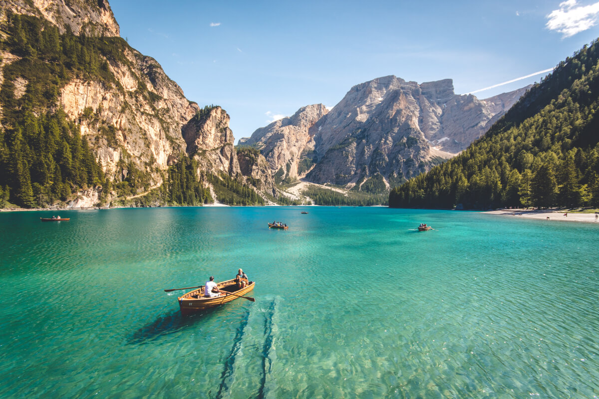 three-brown-wooden-boat-on-blue-lake-water-taken-at-daytime